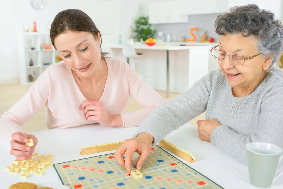 Betreuungskraft spielt gemeinsam mit einer Seniorin